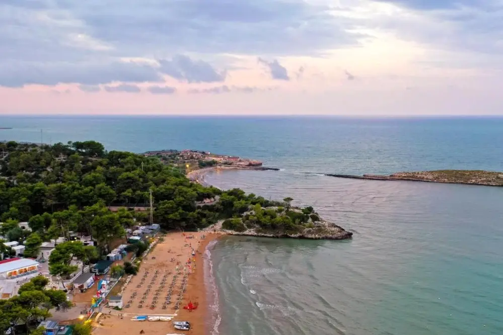 Panoramablick bei Sonnenuntergang auf den Strand und Camping Capo Vieste in Apulien