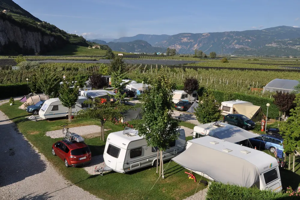 Panoramablick auf die Stellplätze und Südtiroler Weinberge des Camping Obstgarten in Südtirol