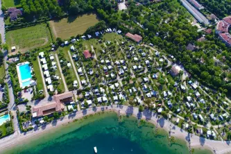 Panoramafoto mit Gardasee, Stellplätzen und Schwimmbad des Campingplatzes Ferienglück Rio