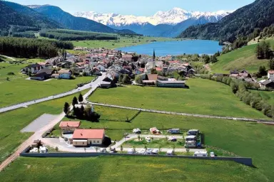 Panoramafoto vom Campingplatz Thöni im Hintergrund der Reschensee und die Alpen