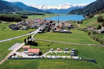 Panoramafoto vom Campingplatz Thöni im Hintergrund der Reschensee und die Alpen