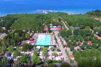 Blick auf das Schwimmbad, die Bungalows und den Gardasee des Eurocamping Pacengo in Pacengo di Lazise