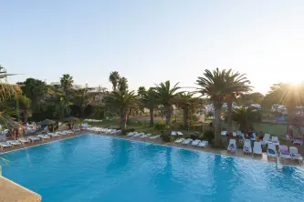 View of the swimming pool with palm trees of the Camping Sporting Center in Veneto