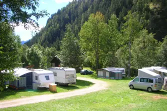 view of the pitches immersed in the Trentino woods of Camping Val di Sole in Pejo