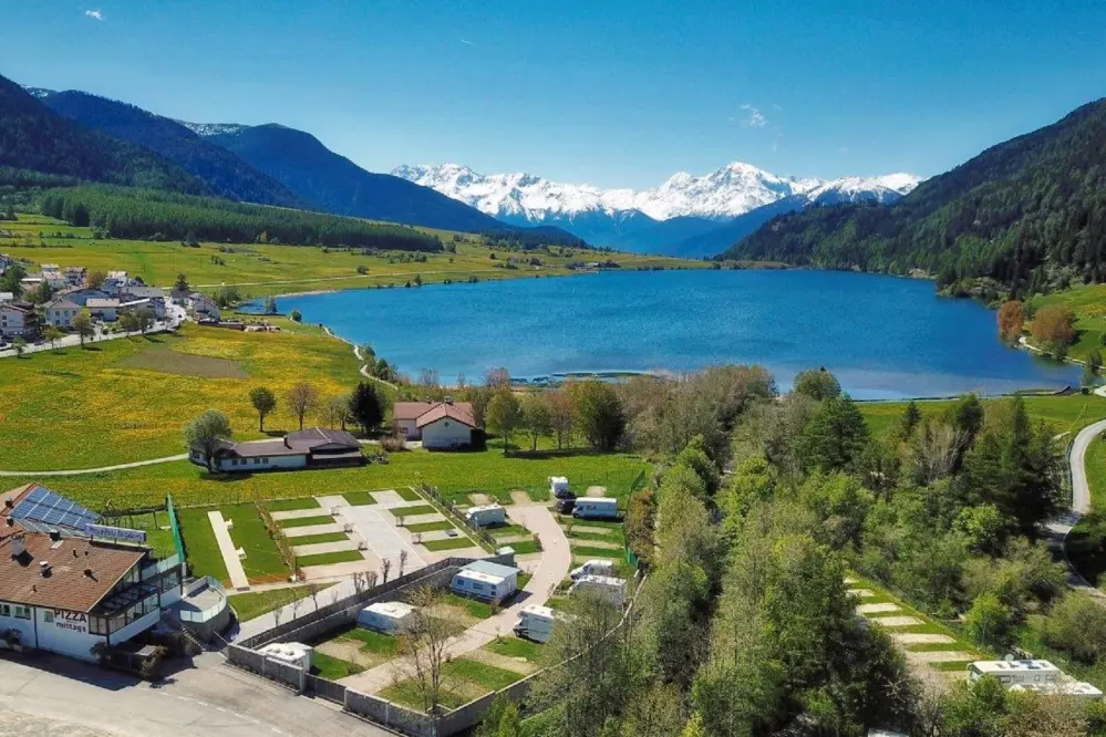 Panoramic view of the camping Zum See with the lake and the Dolomites in South Tyrol in the background