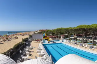 view of the swimming pool and the pine forest of the Village Camping Joker in Veneto