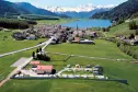 panoramische foto van camping Thöni op de achtergrond het meer van resia en de alpen